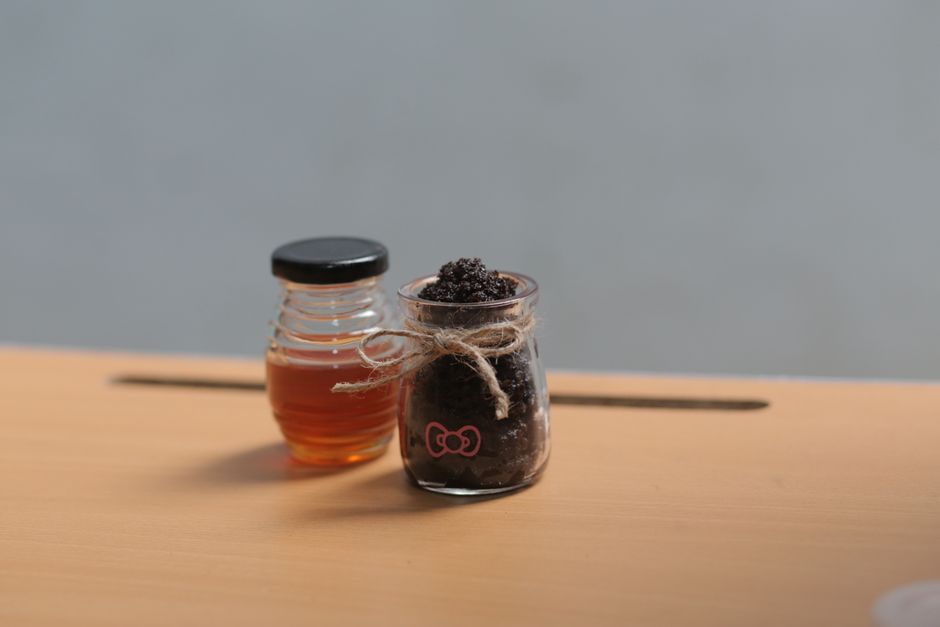 Glass jars with honey and a scrub on a wooden surface, perfect for health or spa themes.