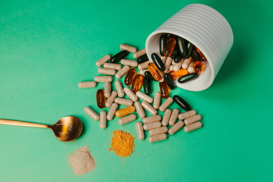 Collagen powder and capsules next to a glass of water