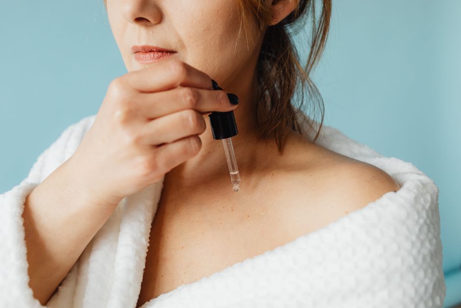 close-up of a woman applying serum to her face