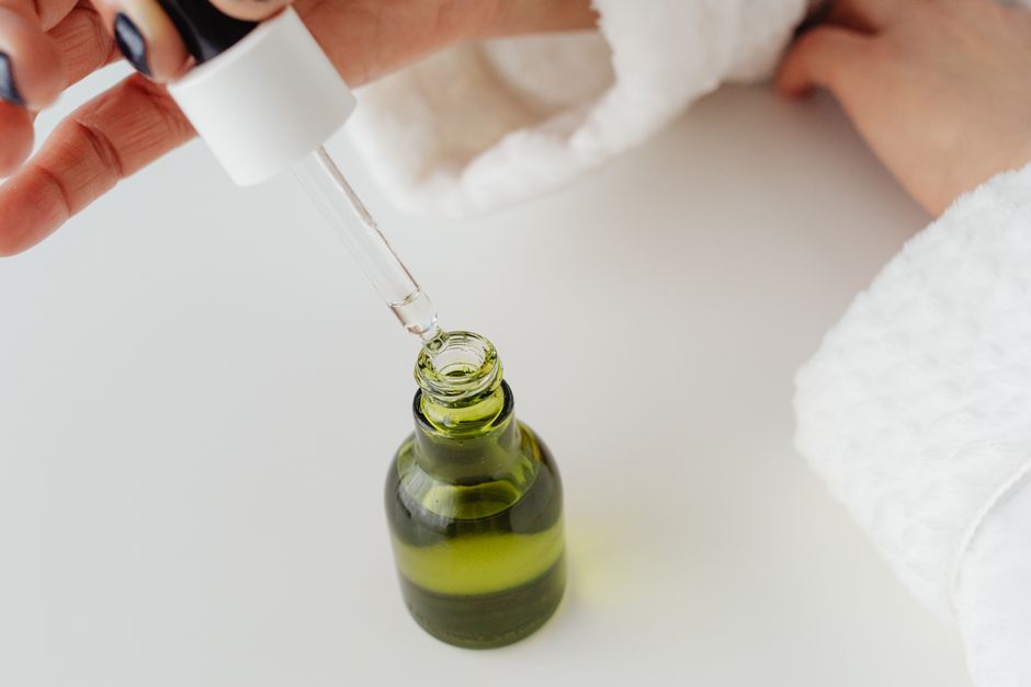 Applying facial oil before a gua sha massage routine