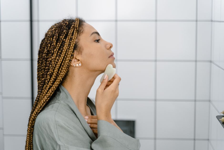 Close-up of gua sha stroke technique along the jawline