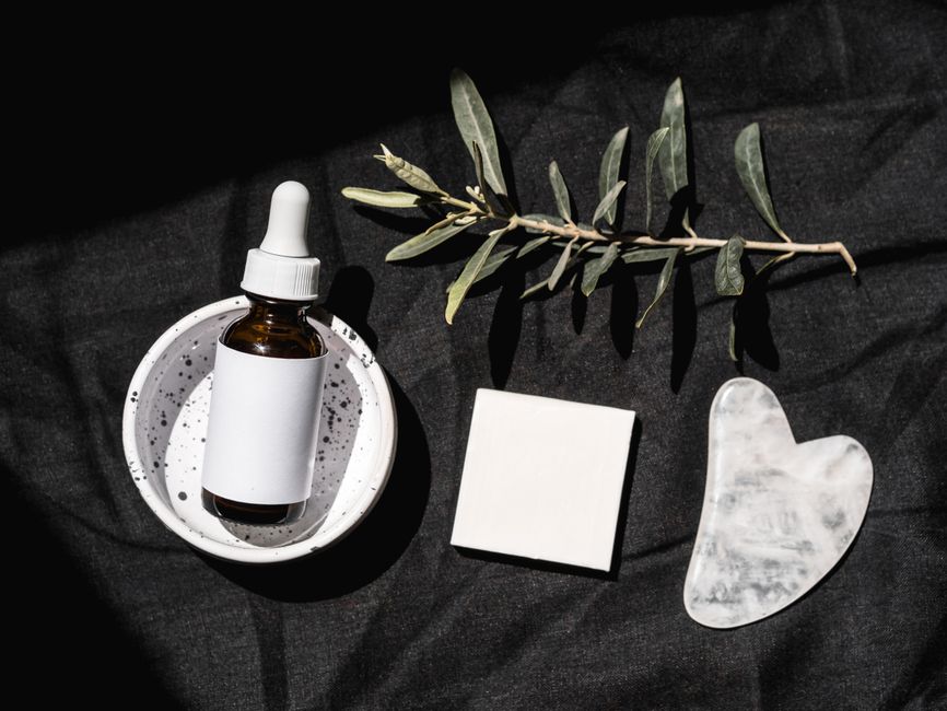 Dropper bottle of chemical exfoliating serum next to a small towel on a marble counter