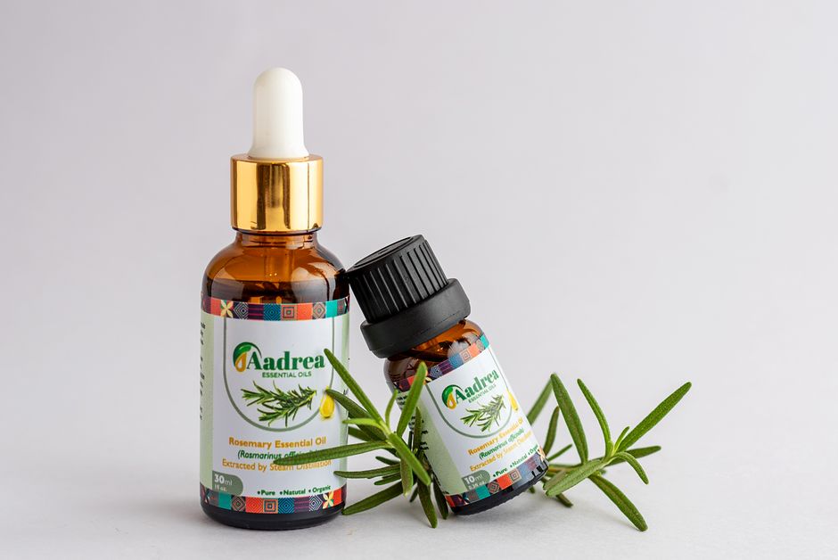 Close-up of rosemary essential oil bottles with fresh rosemary sprig, offering natural aromatic healing.