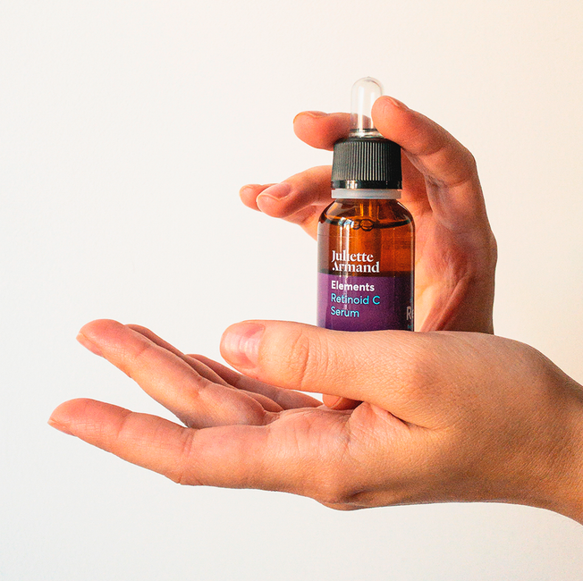 Close-up image of hands holding a cosmetics serum bottle, perfect for skincare themes.