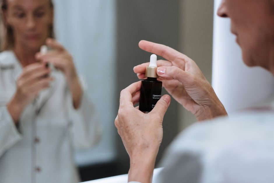 Woman applying antioxidant serum to face during morning skincare routine