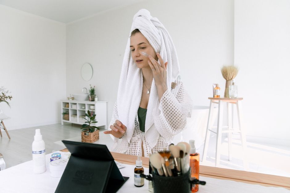 Person applying a few drops of serum to their face during a morning skincare routine